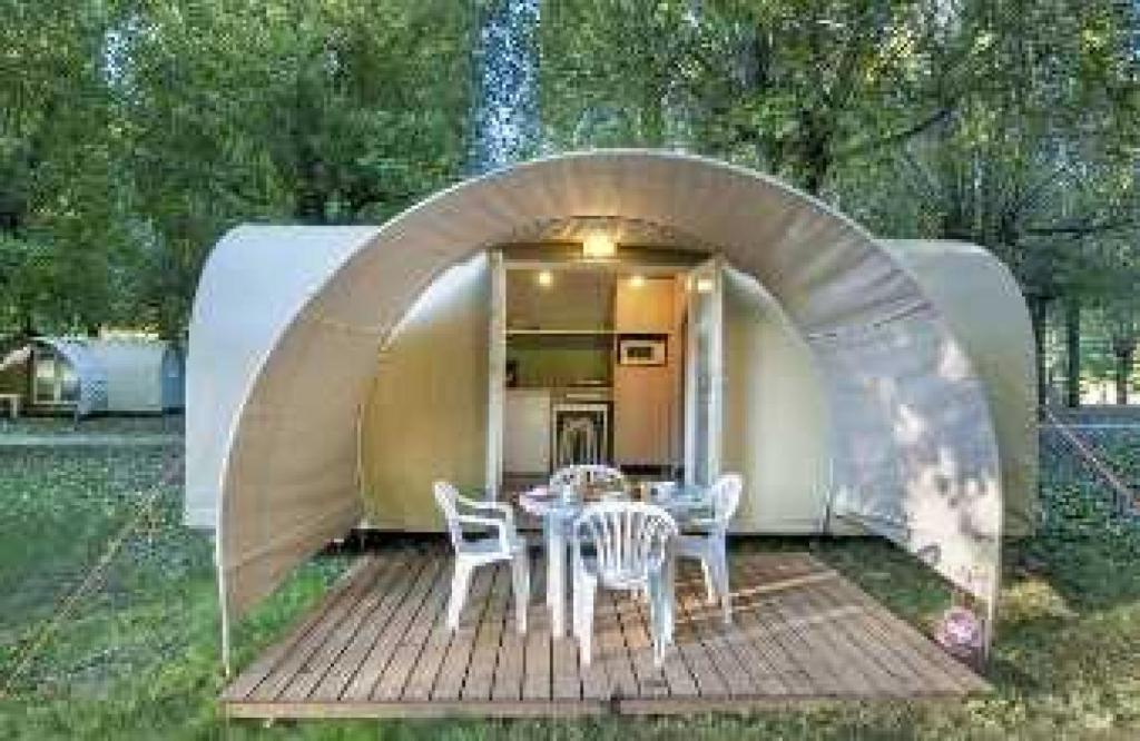 une tente avec une table et des chaises sur une terrasse en bois dans l'établissement Camping 2 étoiles - Piscine - ccab0if, à Saint-Sozy 21 autres photos