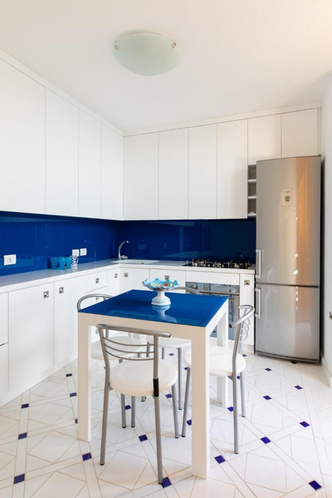 une cuisine avec une table, des chaises et un réfrigérateur dans l'établissement Villa Elizabeth, à Conca dei Marini