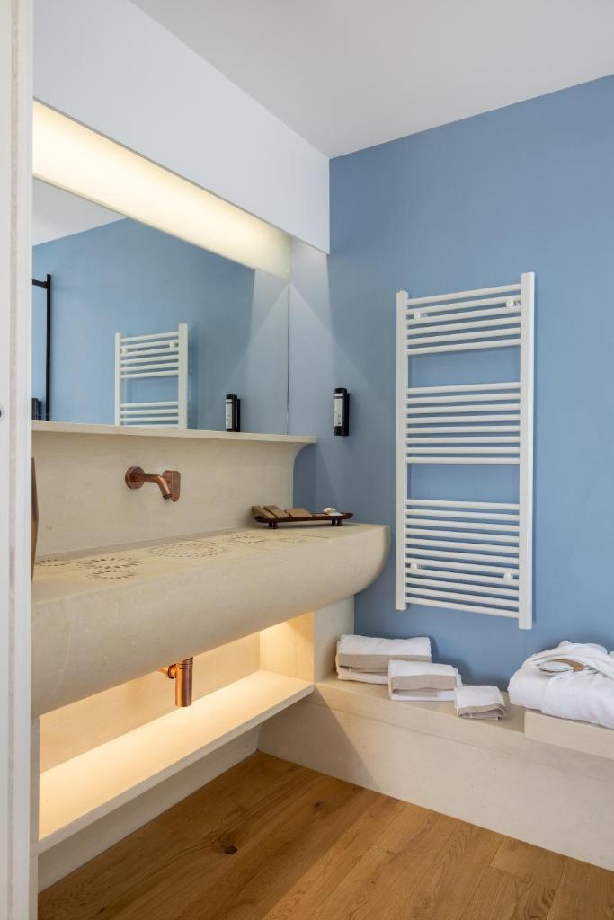 une salle de bain avec des murs bleus et un lavabo dans l'établissement Metamare, à Cozze 94 autres photos