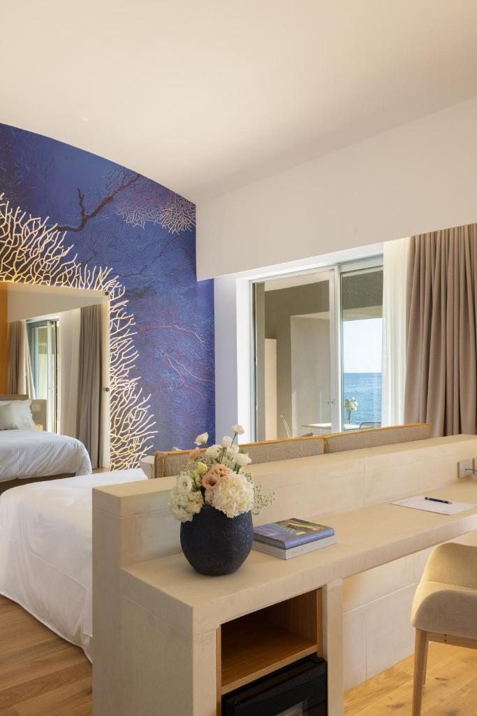 une chambre d'hôtel avec un bureau et un lit dans l'établissement Metamare, à Cozze