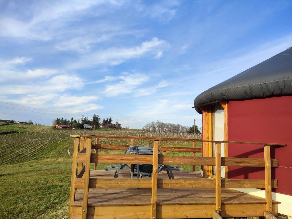 une terrasse avec une table et une vue sur un champ dans l'établissement Chaleureuse yourte a la campagne, à Mourens 1 autre photo