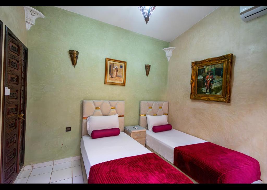 - une chambre avec 2 lits dotés de draps rouges et blancs dans l'établissement Riad Atlas logement entier privé avec jacuzzi au cœur de Marrakesh entire accommodation, à Marrakech