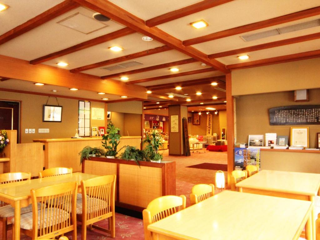 un restaurant avec des tables et des chaises dans une salle dans l'établissement Hotel Uzuraya, à Chikuma