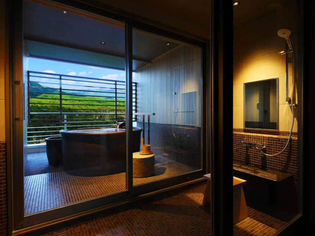 La salle de bains est pourvue d'une baignoire et offre une vue sur un champ. dans l'établissement Arima Grand Hotel, à Kobe