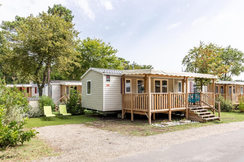 une petite maison avec un porche et une terrasse dans l'établissement Mobilhome 6-8 personnes Cap Ferret, à Lège-Cap-Ferret