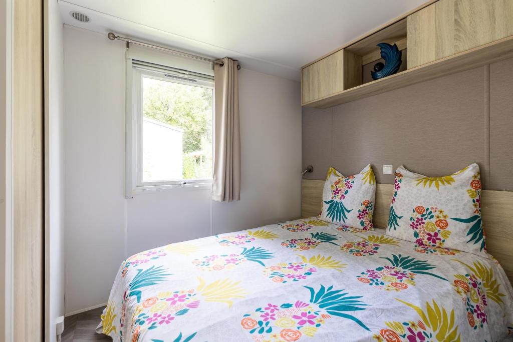une chambre avec un lit avec une couette colorée dans l'établissement Mobilhome 6-8 personnes Cap Ferret, à Lège-Cap-Ferret