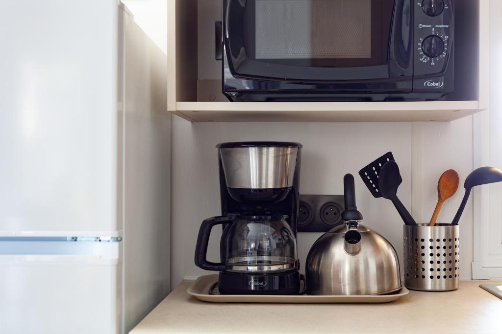 - un comptoir de cuisine avec un mixeur et un four micro-ondes dans l'établissement Mobil home tout équipé, à Carry-le-Rouet