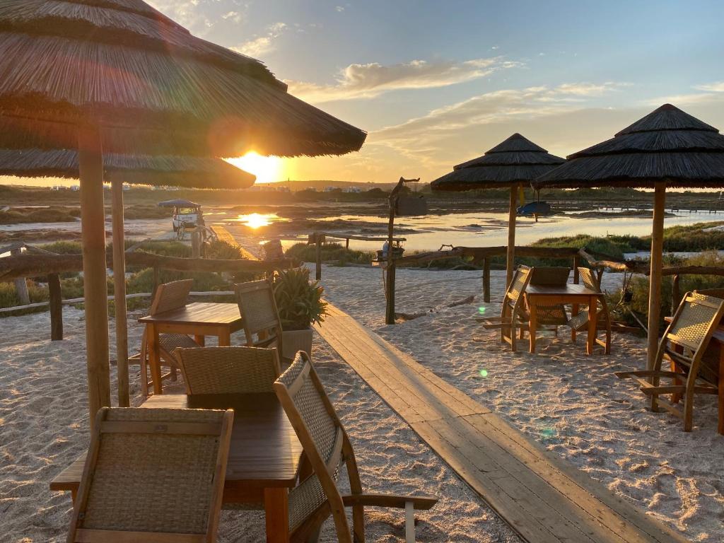- une plage avec des tables et des parasols dans l'établissement Hotel Geranio Rosso, à Stintino