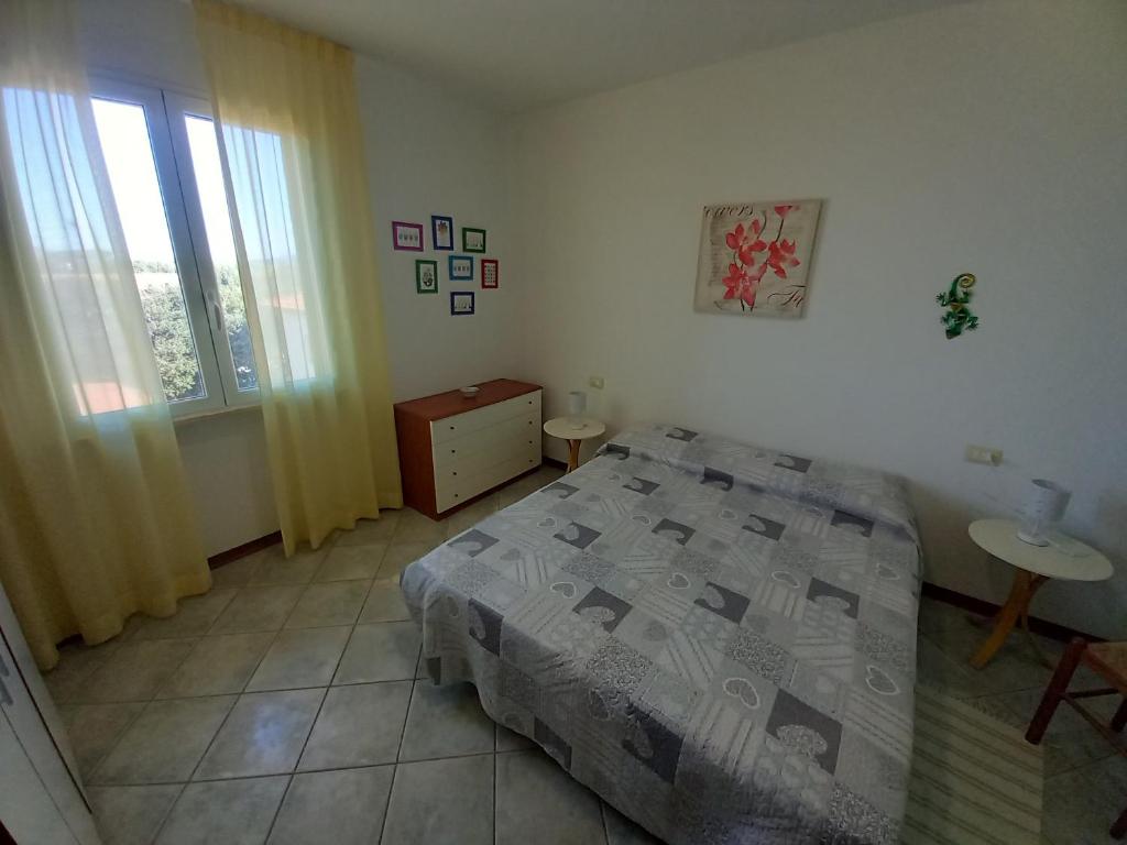 une chambre avec un lit, une table et une fenêtre dans l'établissement Residence Loggetta Margherita, à San Vincenzo