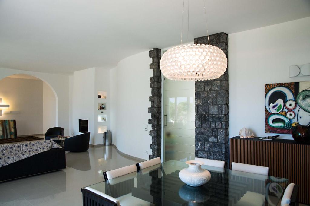 - un salon avec une table en verre et un lustre dans l'établissement Villa Sapore Di Sale, à Alliste