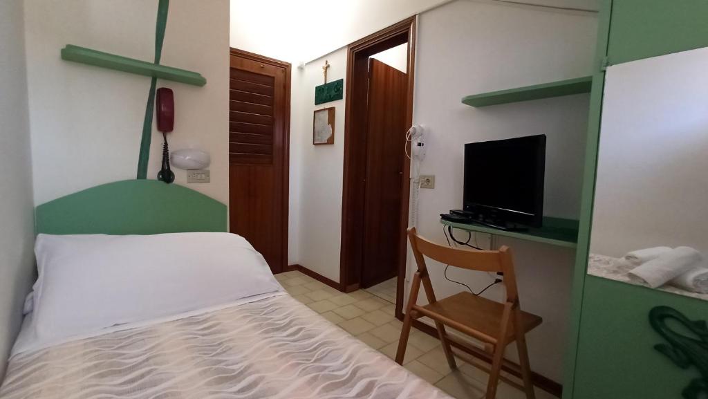 une chambre avec un lit, une chaise et une télévision dans l'établissement Hotel La Caravella, à Bellaria-Igea Marina
