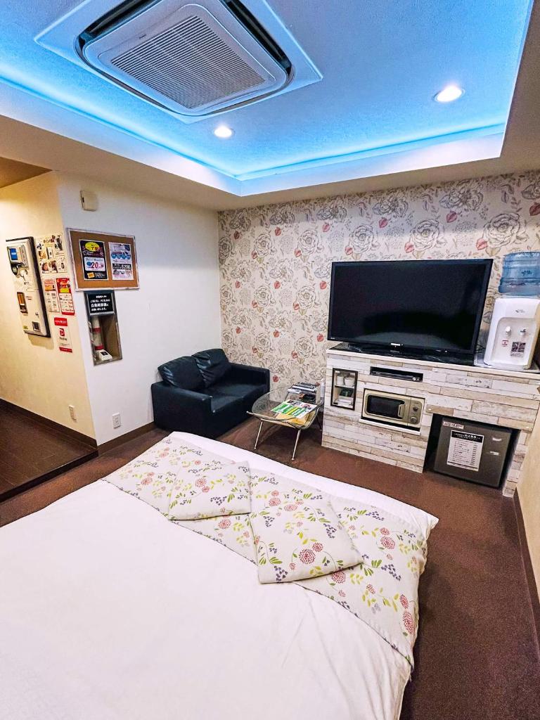 une chambre avec un lit et une télévision à écran plat dans l'établissement Hotel Pal Anesso Nakatsu (Love Hotel), à Nakatsu
