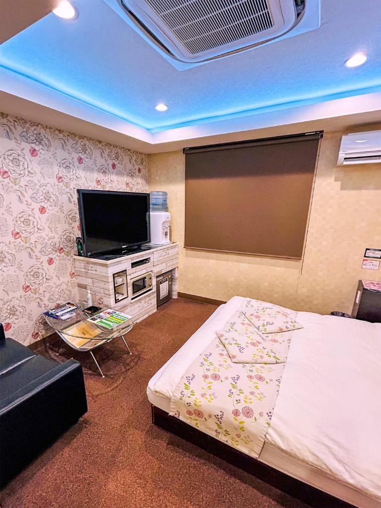 une chambre avec un lit et une télévision à écran plat dans l'établissement Hotel Pal Anesso Nakatsu (Love Hotel), à Nakatsu 16 autres photos