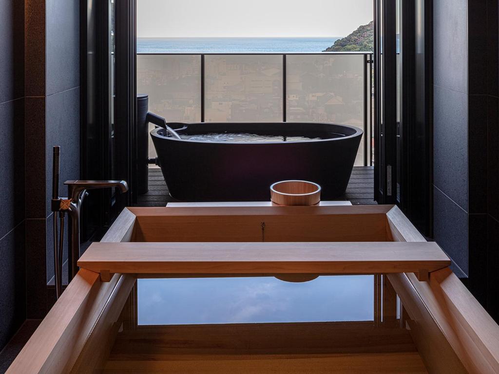 d'une baignoire sur un balcon avec vue sur l'océan. dans l'établissement SOKI ATAMI, à Atami