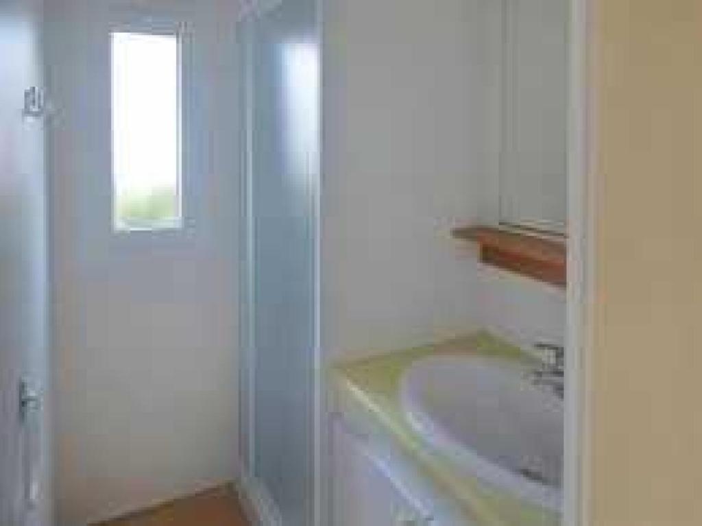une salle de bain blanche avec un lavabo et un miroir dans l'établissement Camping 3 étoiles - Piscine - ccb0ffa, à Fabrezan 37 autres photos