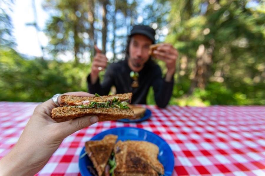 un homme assis à une table avec une assiette de nourriture dans l'établissement Camping maeva Escapades Country Park - Touquin, à Touquin 18 autres photos