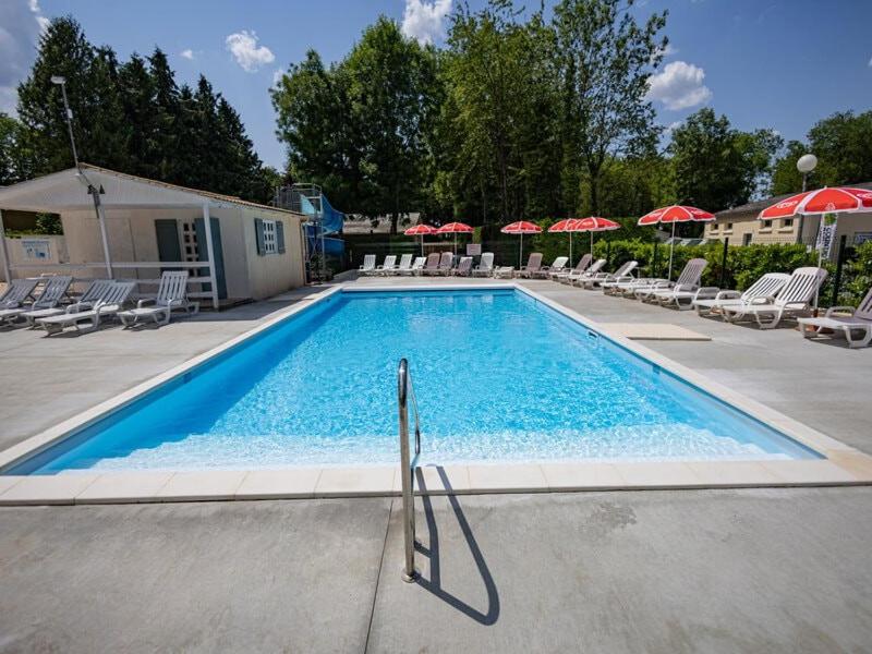 une grande piscine avec chaises et parasols dans l'établissement Camping maeva Escapades Country Park - Touquin, à Touquin
