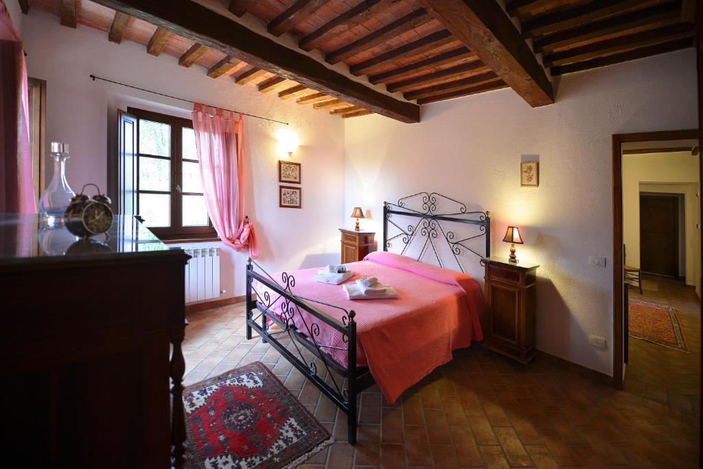 une chambre avec un lit avec un couvre-lit rouge dans l'établissement Podere Suvignano, à Murlo