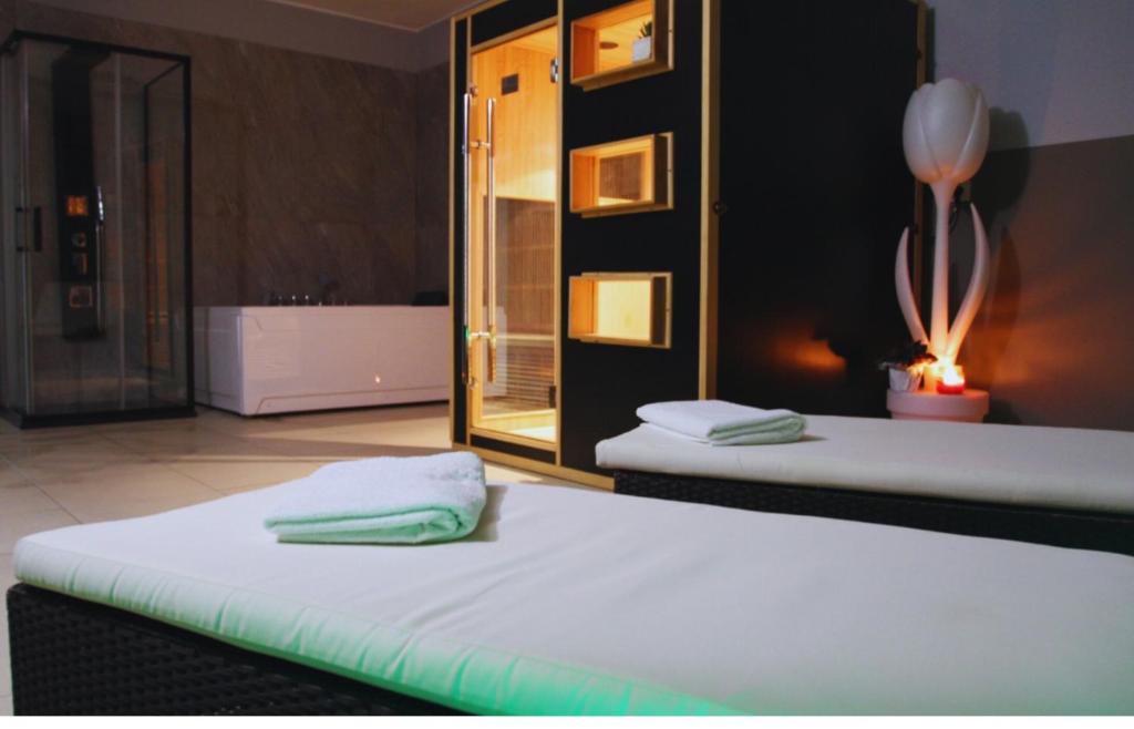 deux lits jumeaux dans une chambre avec un miroir dans l'établissement Happy Hotel Atelier Gardone Riviera Centro & Spa, à Gardone Riviera
