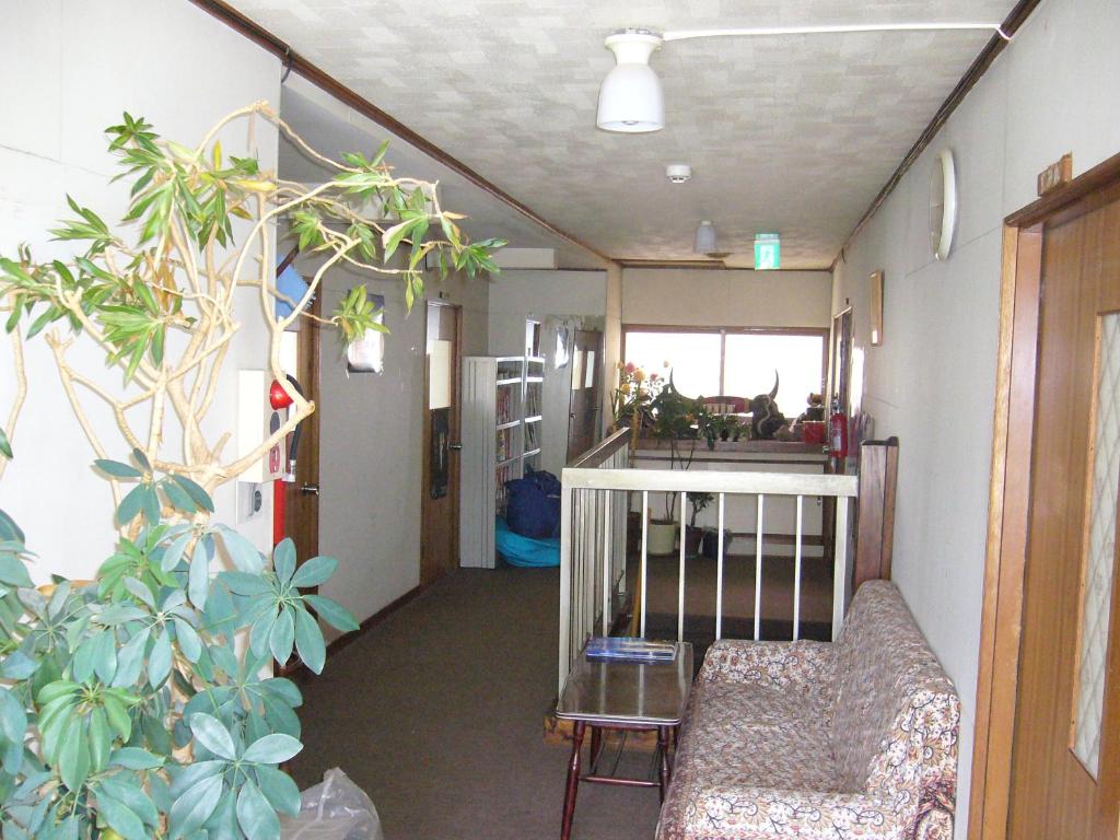 - un couloir avec un canapé et des plantes dans la chambre dans l'établissement Minshuku Mutsukari, à Furano