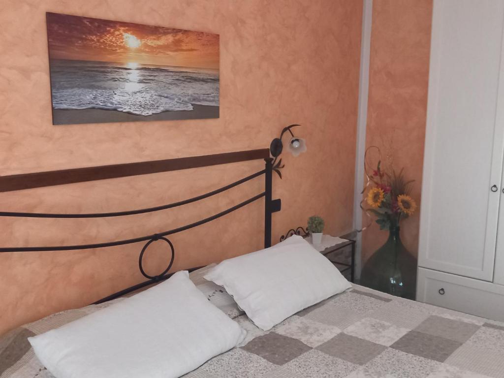 une chambre avec un lit et un tableau au mur dans l'établissement Ca'Melia Villetta, à Sarzana