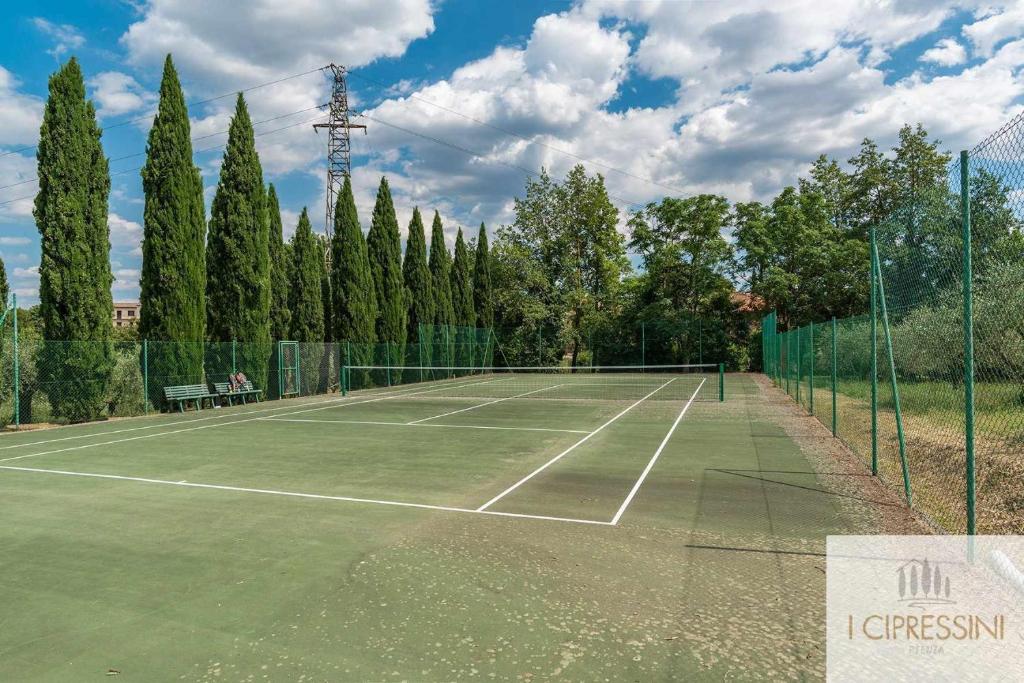 un court de tennis avec des arbres et une clôture dans l'établissement Villa Le Tortore privata lusso piscina relax Siena, à Sienne