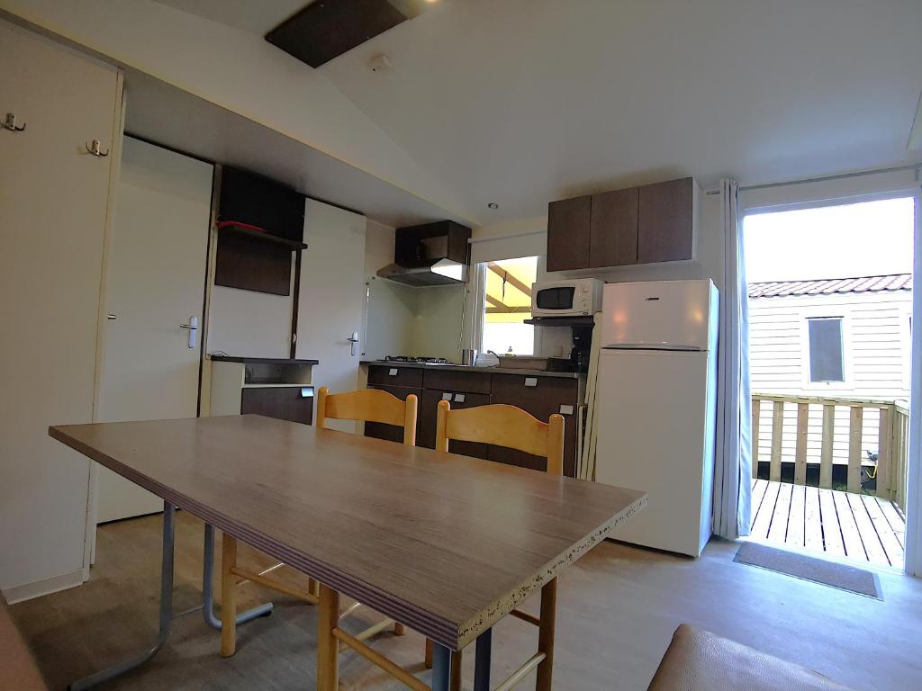 une cuisine avec une table en bois et un réfrigérateur dans l'établissement M,H CONFORT PARIS, 3 Chbr 6 Pers, RER C 40 min piscine 600VOR, à Saint-Chéron