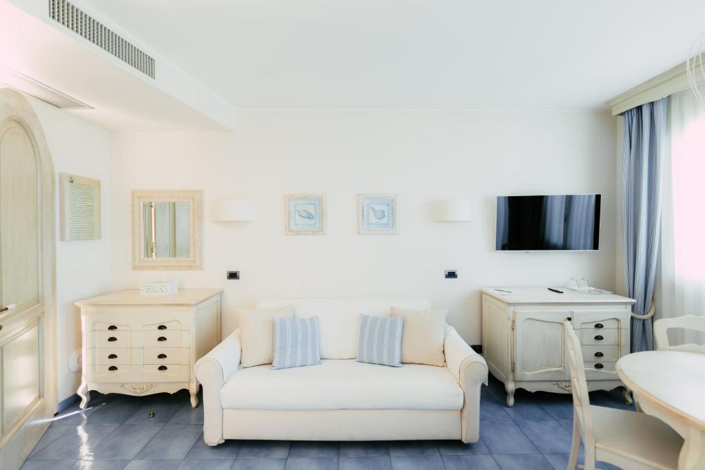 un salon avec un canapé blanc et une télévision dans l'établissement Baia Delphis Resort, à Vasto