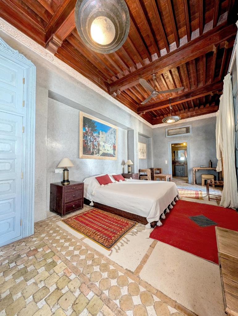 - une chambre avec un grand lit et un plafond en bois dans l'établissement Riad Slitine & Spa, à Marrakech