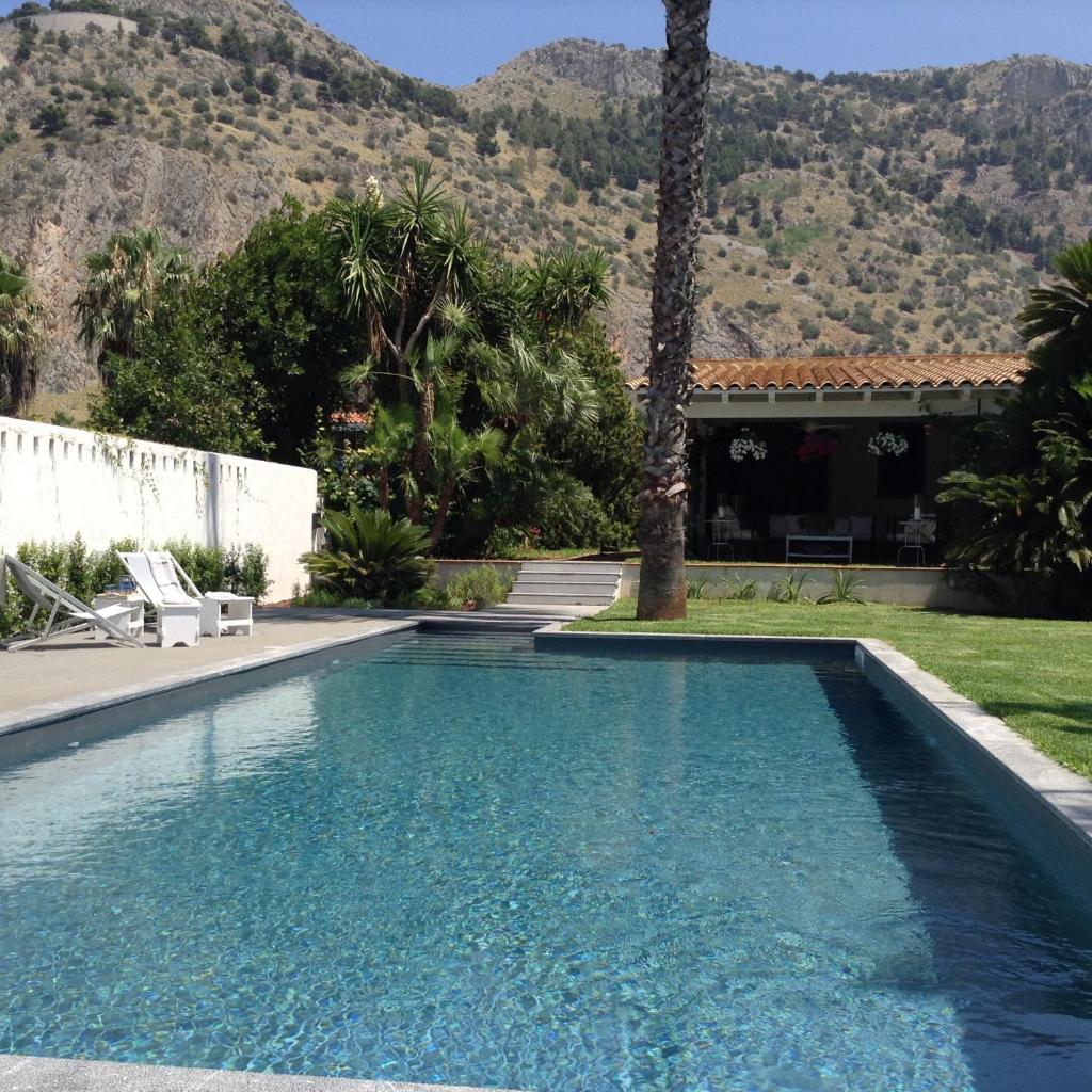une piscine devant une maison avec une montagne dans l'établissement Solemar Sicilia - Villa Mondello, à Palerme