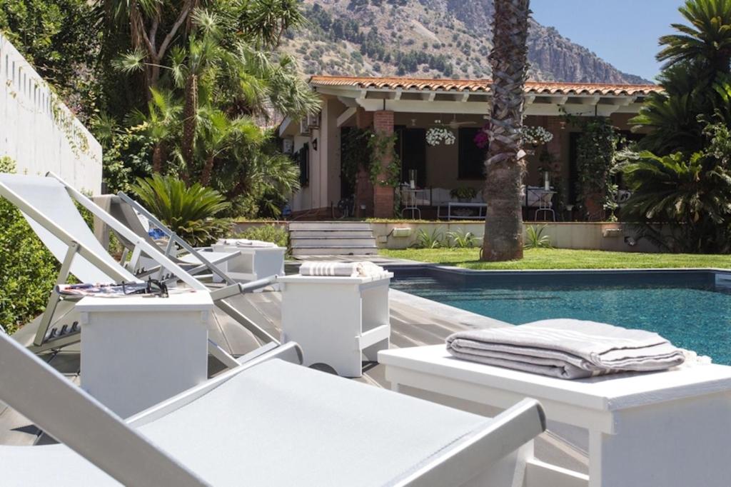 - un groupe de chaises longues à côté de la piscine dans l'établissement Solemar Sicilia - Villa Mondello, à Palerme