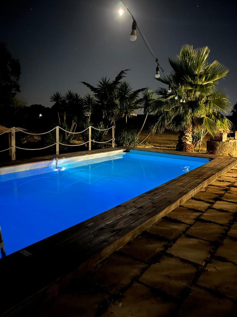 - une piscine bleue la nuit avec une clôture dans l'établissement Villa Rosa, à Alessano