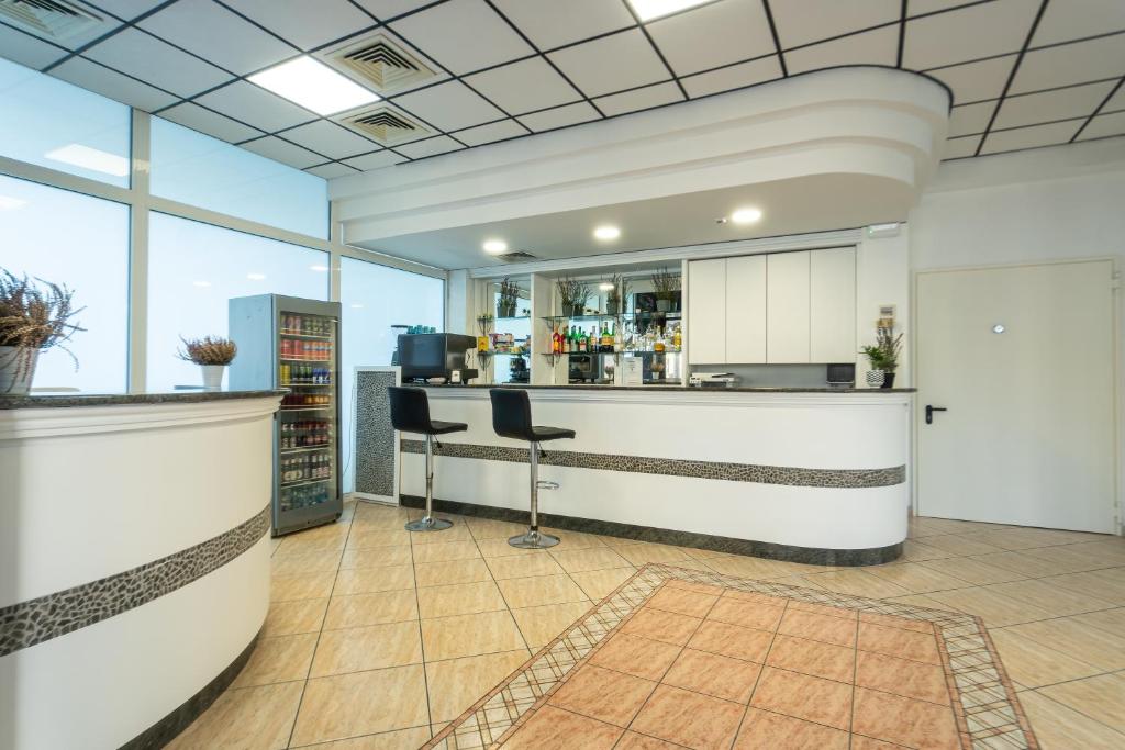 un hall d'entrée avec un bar avec deux tabourets dans l'établissement Hotel Aldebaran, à Rimini