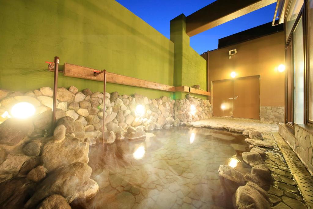 une piscine d'eau éclairée devant un bâtiment dans l'établissement Yutorelo Beppu, à Beppu