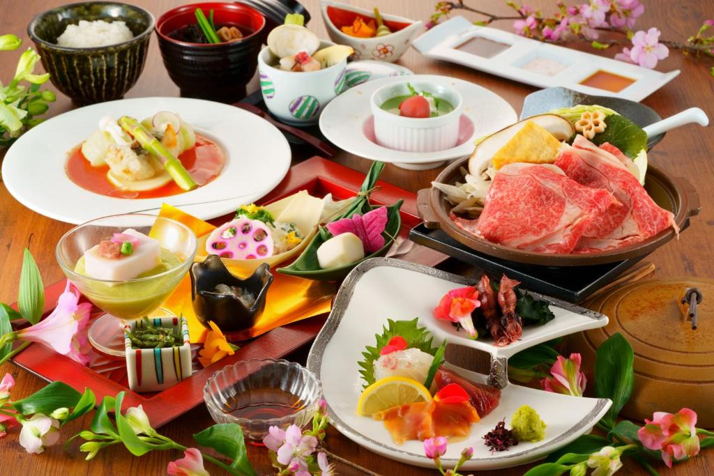 une table avec des assiettes de nourriture sur une table dans l'établissement Yutorelo Beppu, à Beppu