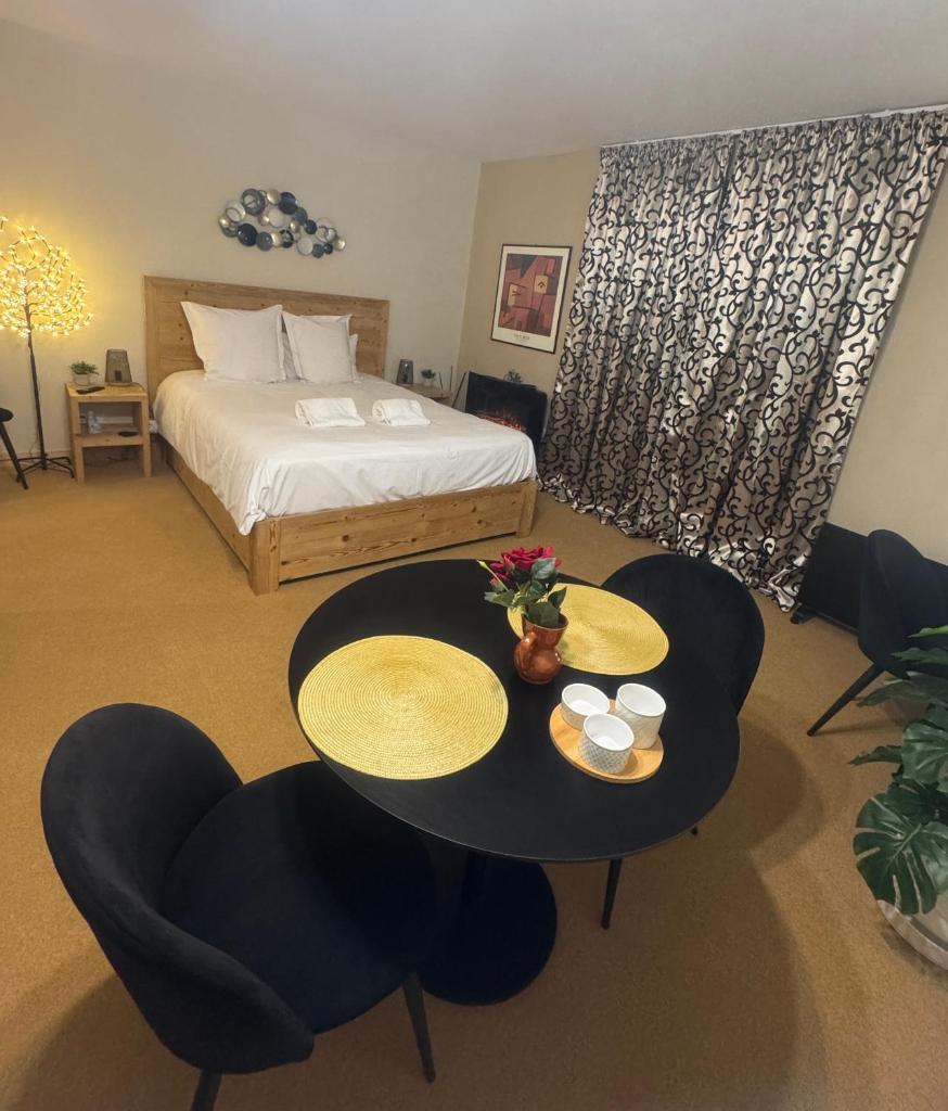 une chambre d'hôtel avec un lit, une table et des chaises dans l'établissement Belle Vue de St Gervais, à Saint-Gervais-les-Bains