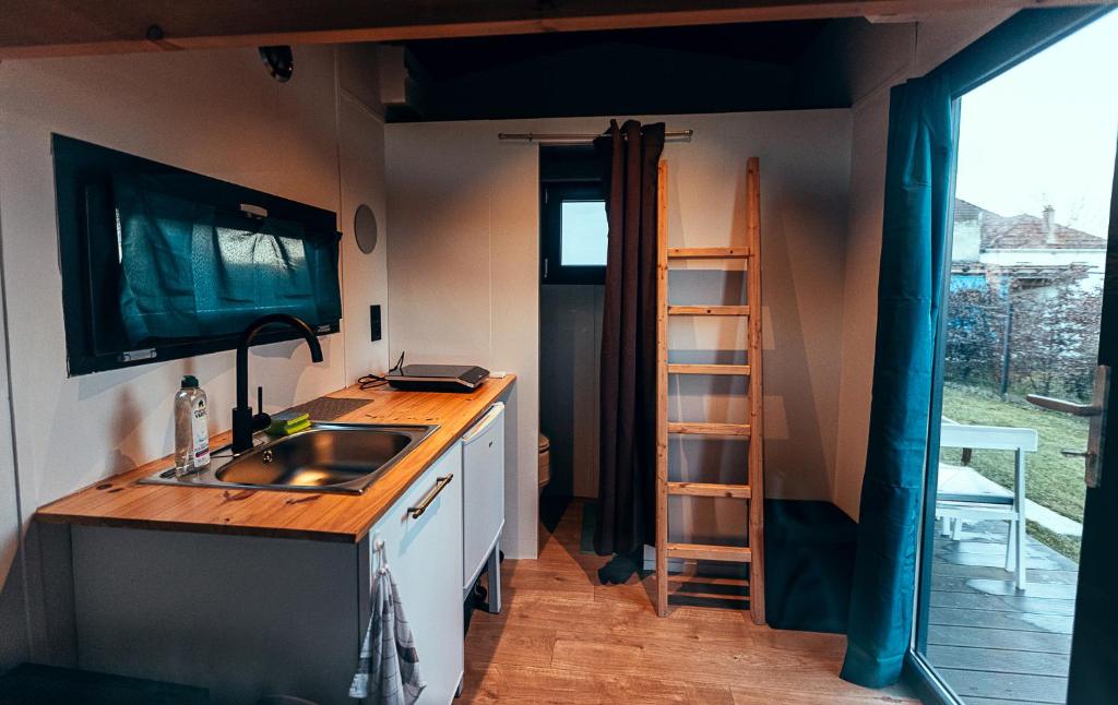 une cuisine avec un évier et un comptoir avec une échelle dans l'établissement Maisonnette des trois frontières, à Richwiller 8 autres photos