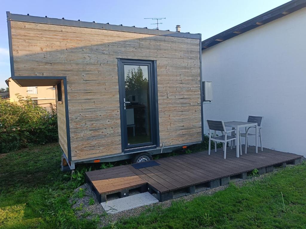 une petite maison avec une table et des chaises sur une terrasse dans l'établissement Maisonnette des trois frontières, à Richwiller