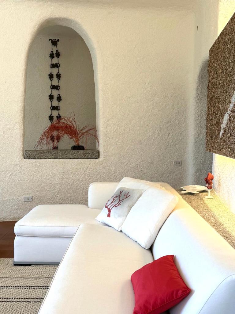 - un salon avec un canapé blanc et des oreillers rouges dans l'établissement Sa Maluni, à Marongiu