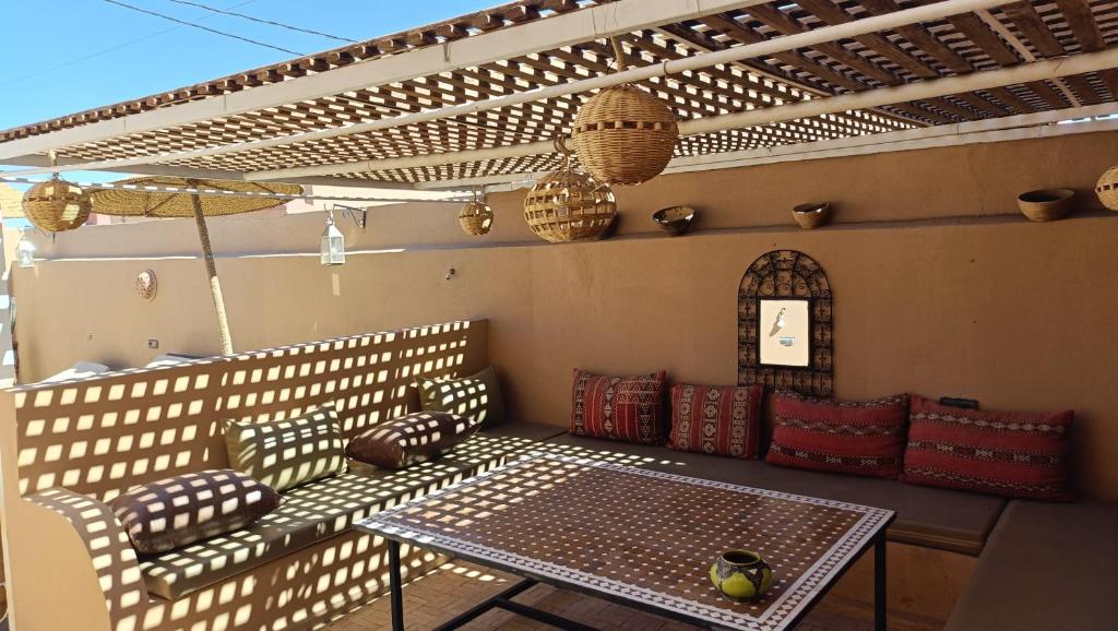 un patio avec une table et des chaises sur un patio dans l'établissement Riad Dar Poublanc, à Merzouga