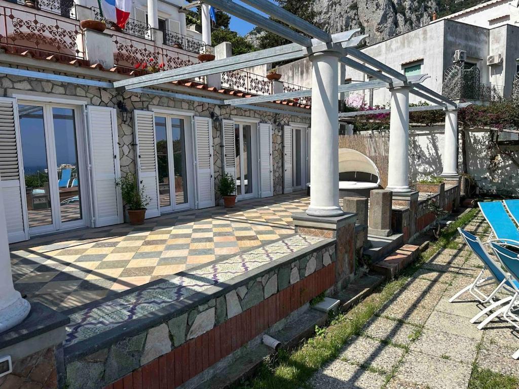 une maison avec une terrasse dotée de chaises et une piscine dans l'établissement Villa Amalu Capri Piscina e Giardino, à Capri