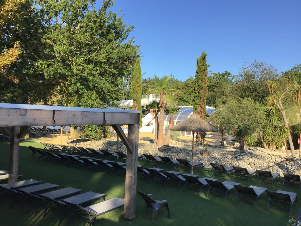 - une rangée de chaises et un parasol dans un parc dans l'établissement Mobil home neuf, à Biscarrosse 18 autres photos