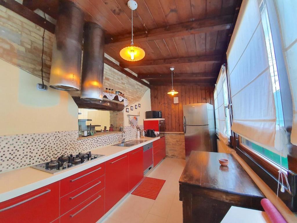 une cuisine avec des armoires rouges et une grande fenêtre dans l'établissement Villa Martin with private pool for 5 people, à Montegranaro