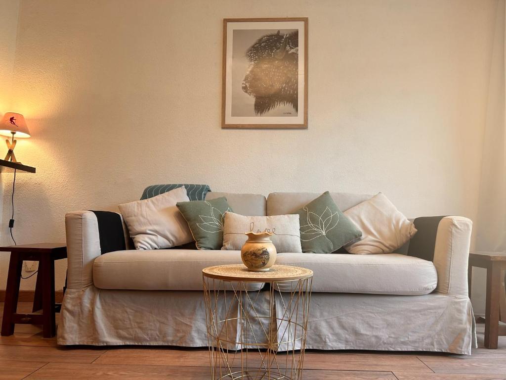un salon avec un canapé et une table dans l'établissement Carla's Residences - Le Margériaz, à Aillon-le-Jeune