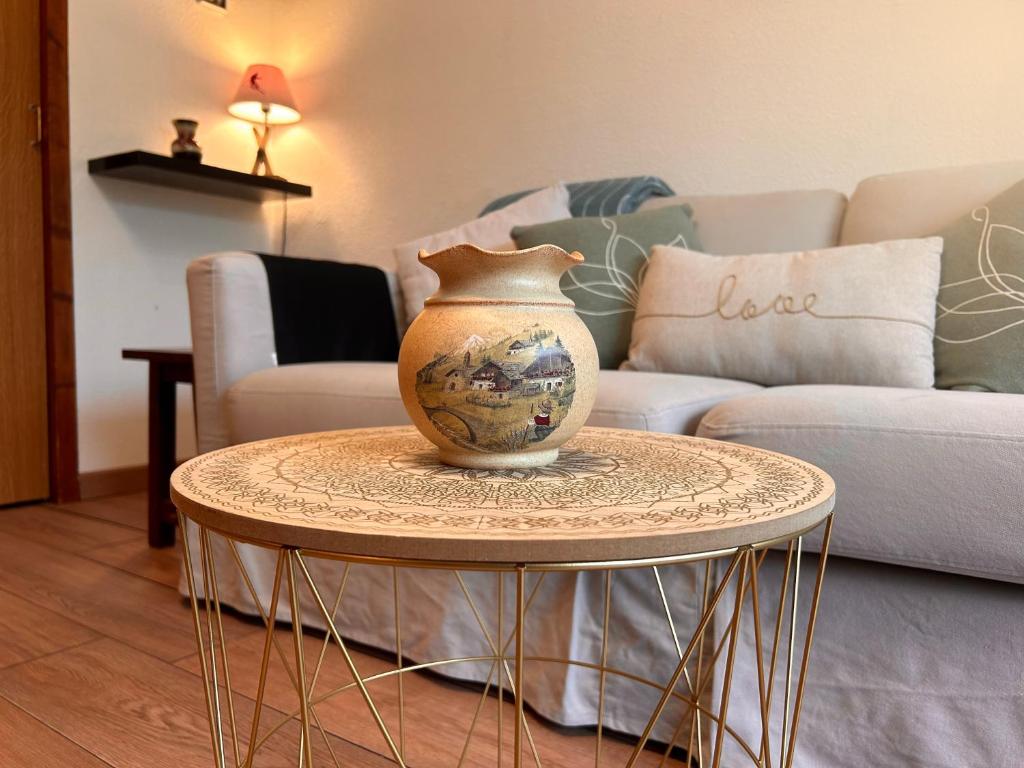 un vase assis sur une table dans un salon dans l'établissement Carla's Residences - Le Margériaz, à Aillon-le-Jeune