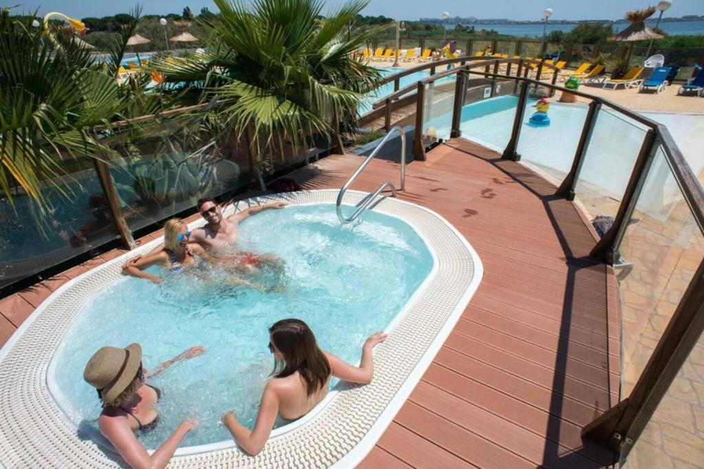 un groupe de personnes dans une piscine d'un complexe hôtelier dans l'établissement mobil home chaleureux et idyllique, à Lattes
