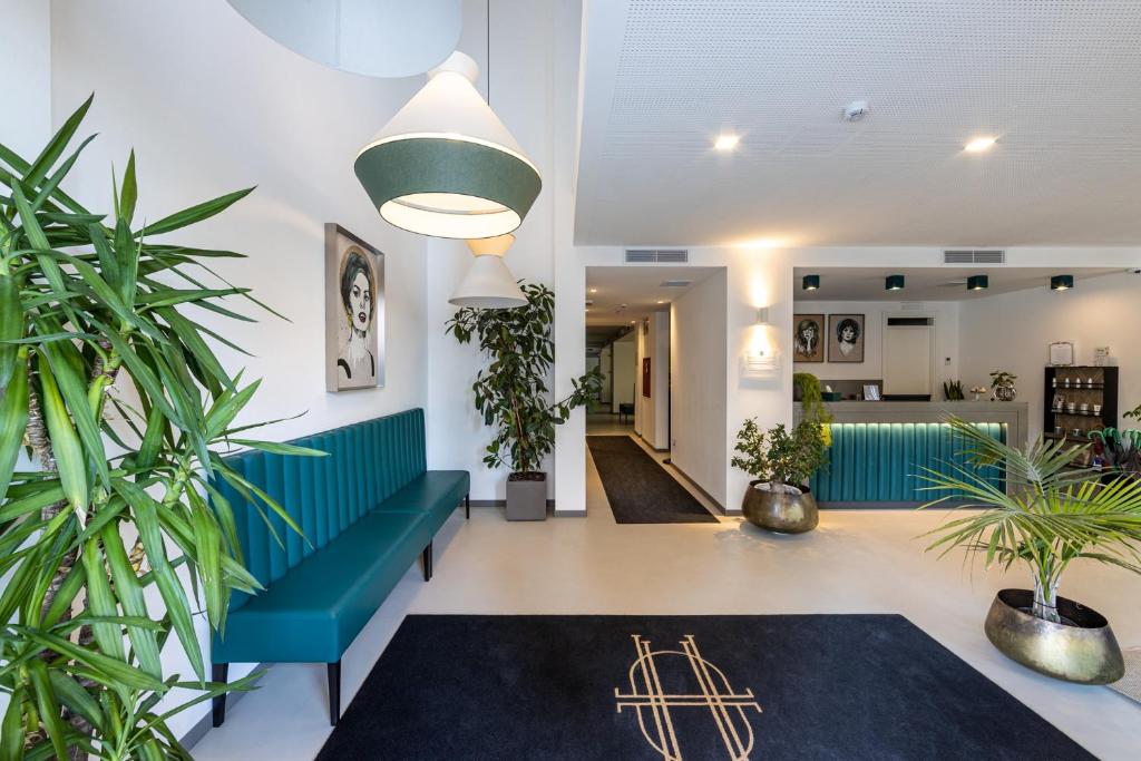 un hall avec un canapé vert et des plantes dans l'établissement DIVA HOTEL LIGNANO - Adults Only, à Lignano Sabbiadoro