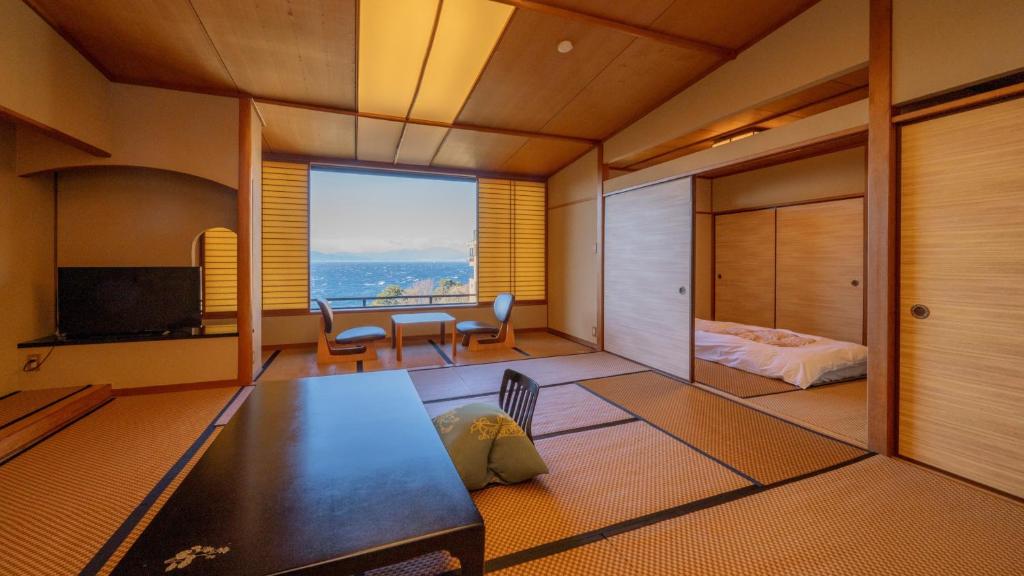 - un salon avec vue sur une chambre et un lit dans l'établissement Nishiizu Koyoi, à Numazu