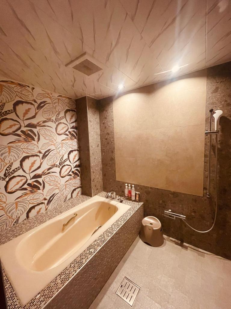 une salle de bain avec baignoire et douche dans l'établissement リンドス, à Okayama