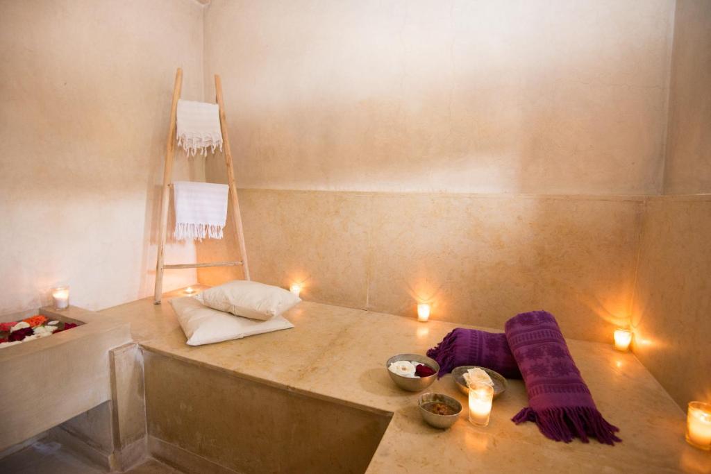 Cette chambre comprend une table avec des couvertures violettes et des bougies. dans l'établissement Riad Dar 73, à Marrakech